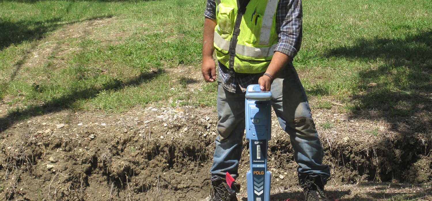 SUE crew member working on land development with tool in ground